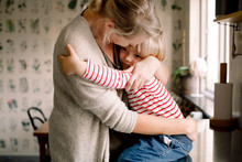 Mother Embracing Daughter In Kitchen
