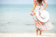 Relax traveler asia woman in dress holding sun hat standing on beach  enjoys her tropical  vacation