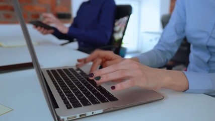 Poster - unrecognizable business people working using computer sitting at the desk in office with casual interior. businesswoman typing on laptop businessman holding digital tablet