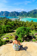 © Simon Dannhauer - Koh Phi Phi Don, Viewpoint - Girl enjoying beautiful view of paradise bay from the top of the tropical island. View from the back. Thailand.