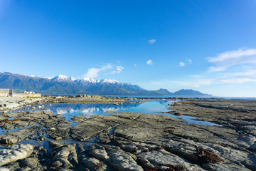 Sticker - Snow-capped Kaikoura Mountains reflected in calm rockpool