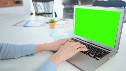 Fototapete - unrecognizable businesswoman using pc with green screen at workplace. female wearing bright blue shirt working use computer sitting at the white desk