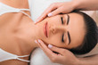 © Peakstock - young woman getting a head massage at a spa. Face massage with perfect clean and fresh skin
