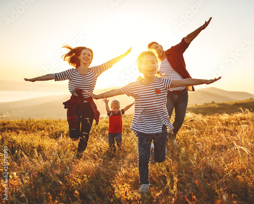 Fotomural Happy family: mother, father, children son and daughter on sunset