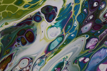 Close-up of abstract acrylic pour painting in pcurple, blue, and green.