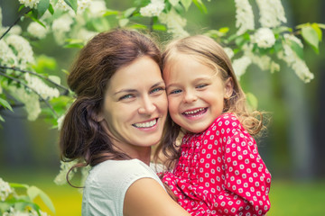 Portrait of happy mother and little daughter in spring park