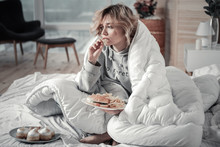 Sad And Lonely Woman Eating Burger And French Fries In The Bed