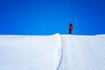 Wall Mural - Young Woman Tourist walking in snow mountain Matterhorn peak, Zermatt, Switzerland.