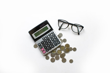 Poster - Top view of financial calculations with calculator, coins and eye glasses on a white desk.