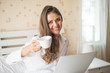 © Johnstocker - Happy Beautiful woman working on a laptop on the bed in the house