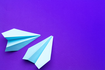 Wall Mural - white paper airplane on a purple background