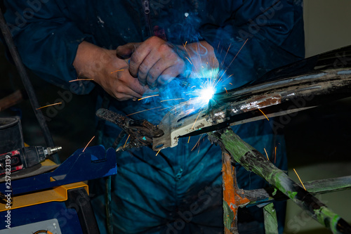 Close Up View Strong Man Is A Welder In Blue Working Overalls