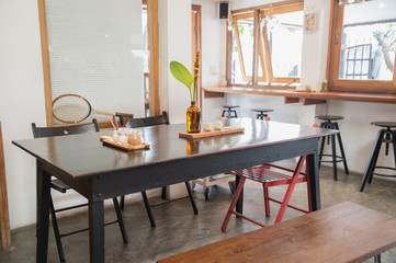 Wall Mural - Interior of wooden table and chairs with foliage decoration