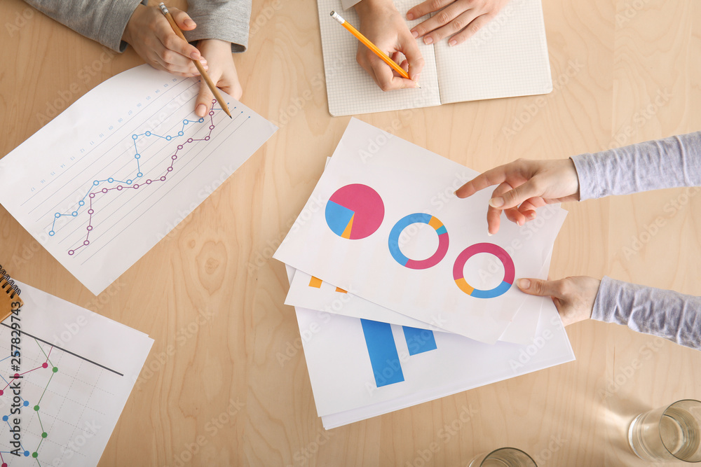 Colleagues sitting at table during business meeting in conference hall