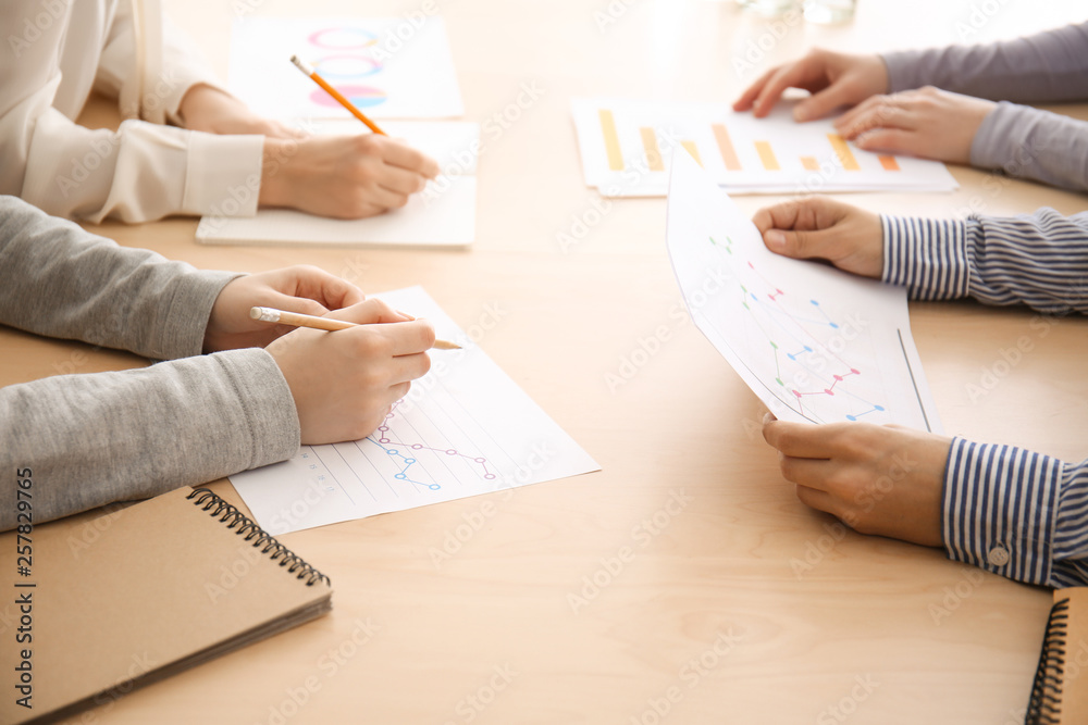Colleagues sitting at table during business meeting in conference hall
