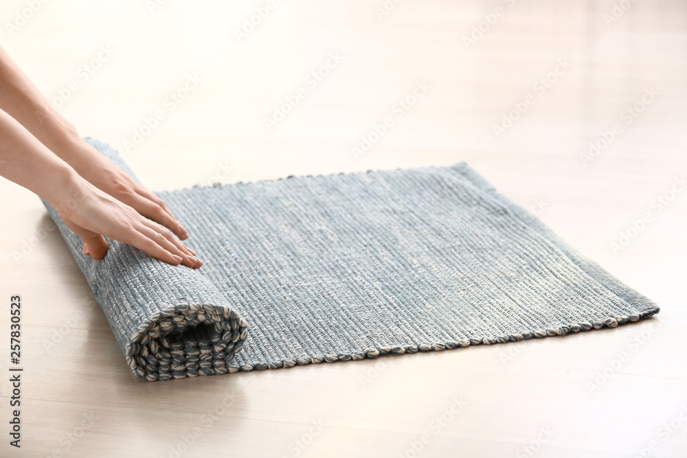 Worker rolling rug on floor