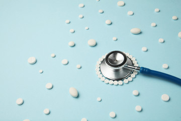 Wall Mural - Medical stethoscope and pills on blue background. Health care.