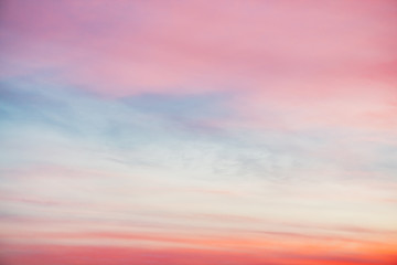 Sunset sky with pink orange light clouds. Colorful smooth blue sky gradient. Natural background of sunrise. Amazing heaven at morning. Slightly cloudy evening atmosphere. Wonderful weather on dawn.