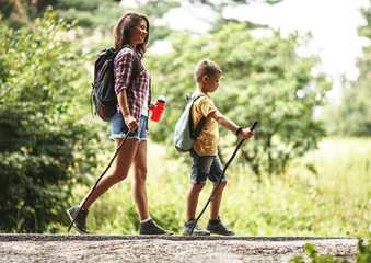 Wall Mural - mother and her little son hiking by the rural country road.outdoor spring leisure concept.