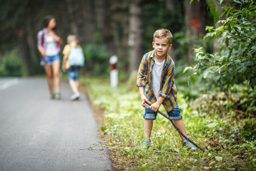 Wall Mural - family hiking.little boy stands on front and playing with stick.