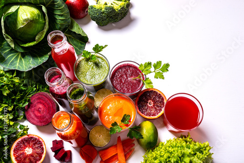 Different healthy vegan drinks with fruits and vegetables on the white wooden background. Flat lay. © ronedya