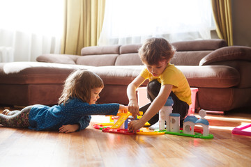 Cute two little children playing with toys at home 