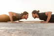 Two twin brothers doing exercises at the beach together