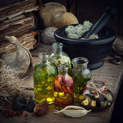 Wall Mural - Bottles of essential oil or potion, mortar of dried moss, old books, dry roots and plants. Herbal medicine.