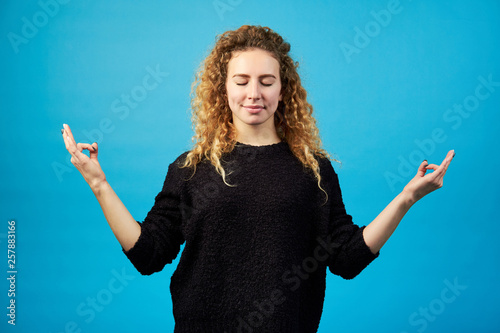 Fotomural Smiling young restful attractive confident redhead curly woman with meditate han
