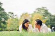 © ic36006 - Portrait of happy  young asian couple laying on grass In public park.