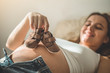 © Анастасія Стягайло - Beautiful pregnant woman holds small child clothes. Concept of pregnancy