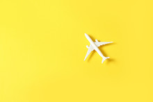 Miniature Toy Airplane On Yellow Background. Trip By Airplane.