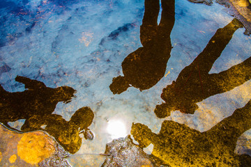 View of reflection of people on the water.