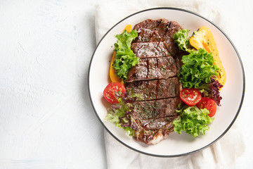 Grilled beef steak and fresh vegetables on plate