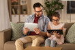 © Syda Productions - family, fatherhood and technology concept - happy father and daughter in glasses with tablet pc computers at home