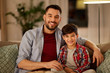 © Syda Productions - family, childhood, fatherhood, leisure and people concept - portrait of happy smiling father and little son hugging at home in evening