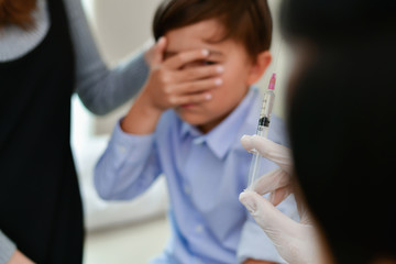 Wall Mural - Terrible medical concept. Children are afraid of syringes. The doctor is injecting patients.