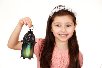 Happy young Muslim girl playing with lantern in Ramadan