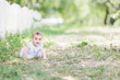 © laniko - baby girl wearing white dress sitting on the grass