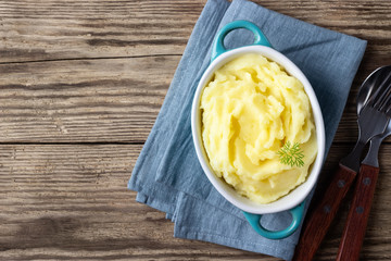 Wall Mural - Mashed potatoes in bowl on wooden rustic background. Top view. Copy space.