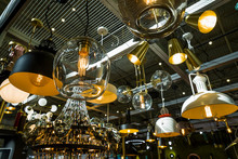 Luminous Chandeliers On A Metal Frame Under The Ceiling Of The Store