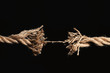 © New Africa - Rupture of cotton rope on black background