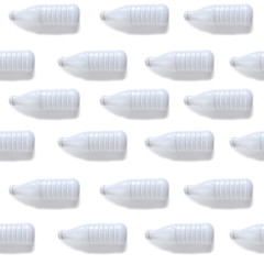 Seamless pattern of white plastic milk bottles on white background. Flat lay minimal concept design