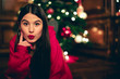 © Westend61 - Portrait of teenage girl with Christmas tree in the background pouting mouth