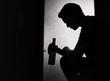 silhouette of a young sad man drinking alcohol alone
