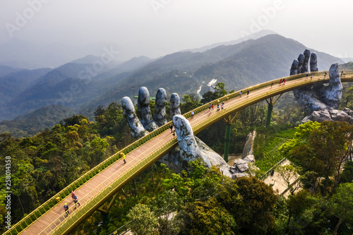 Fotografía Top aerial view of the famous Golden Bridge is lifted by two giant hands in the tourist resort on Ba Na Hill in Danang, Vietnam