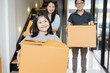 © saksit - Portrait of happy Asian family moving to new house with cardboard boxes.