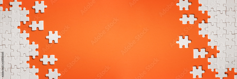 White details of puzzle on orange background - obrazy, fototapety, plakaty 