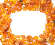 Frame made with chips of orange Baltic amber isolated on white. The Baltic region is home to the largest known deposit of amber, called Baltic amber or succinite. For making jewellery.
