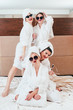 Girls hangout. Leisure joy. Cheerful women posing on bed. Sunglasses, bathrobes and towel turbans on. Weekend time.